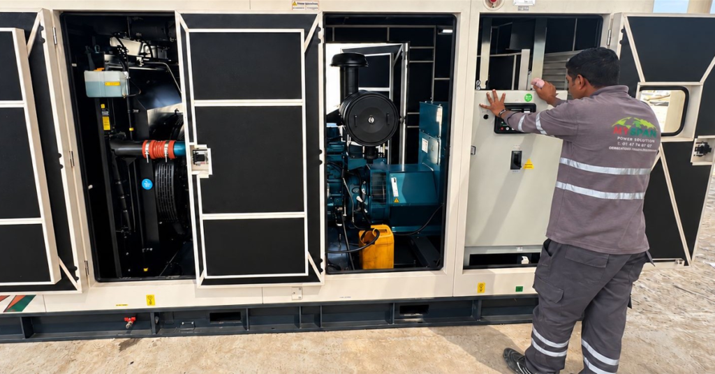 Technician inspecting a Kirloskar diesel generator with its service doors open